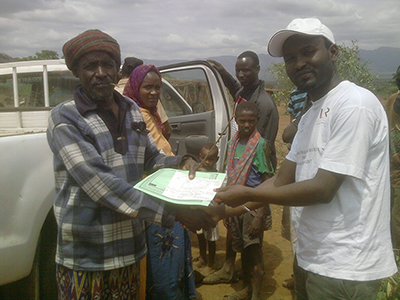 pastoralist receiving insurance policy doc