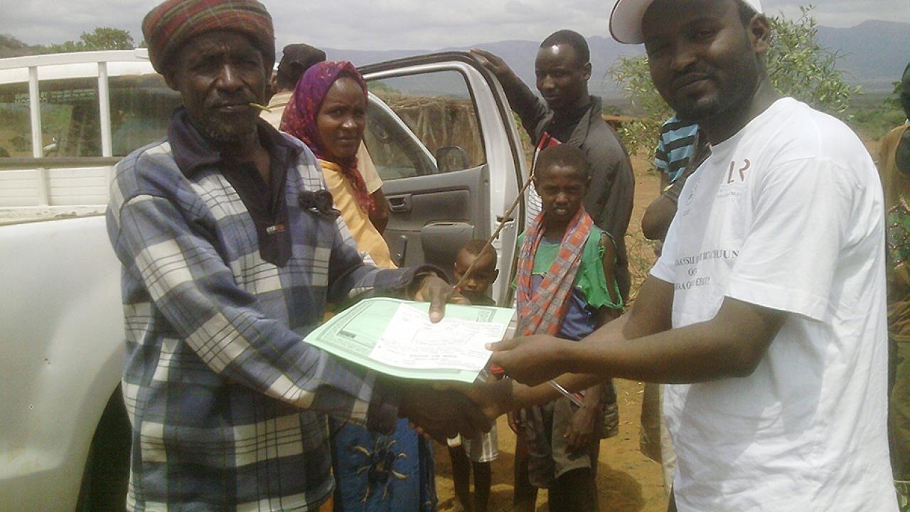 pastoralist receiving insurance policy